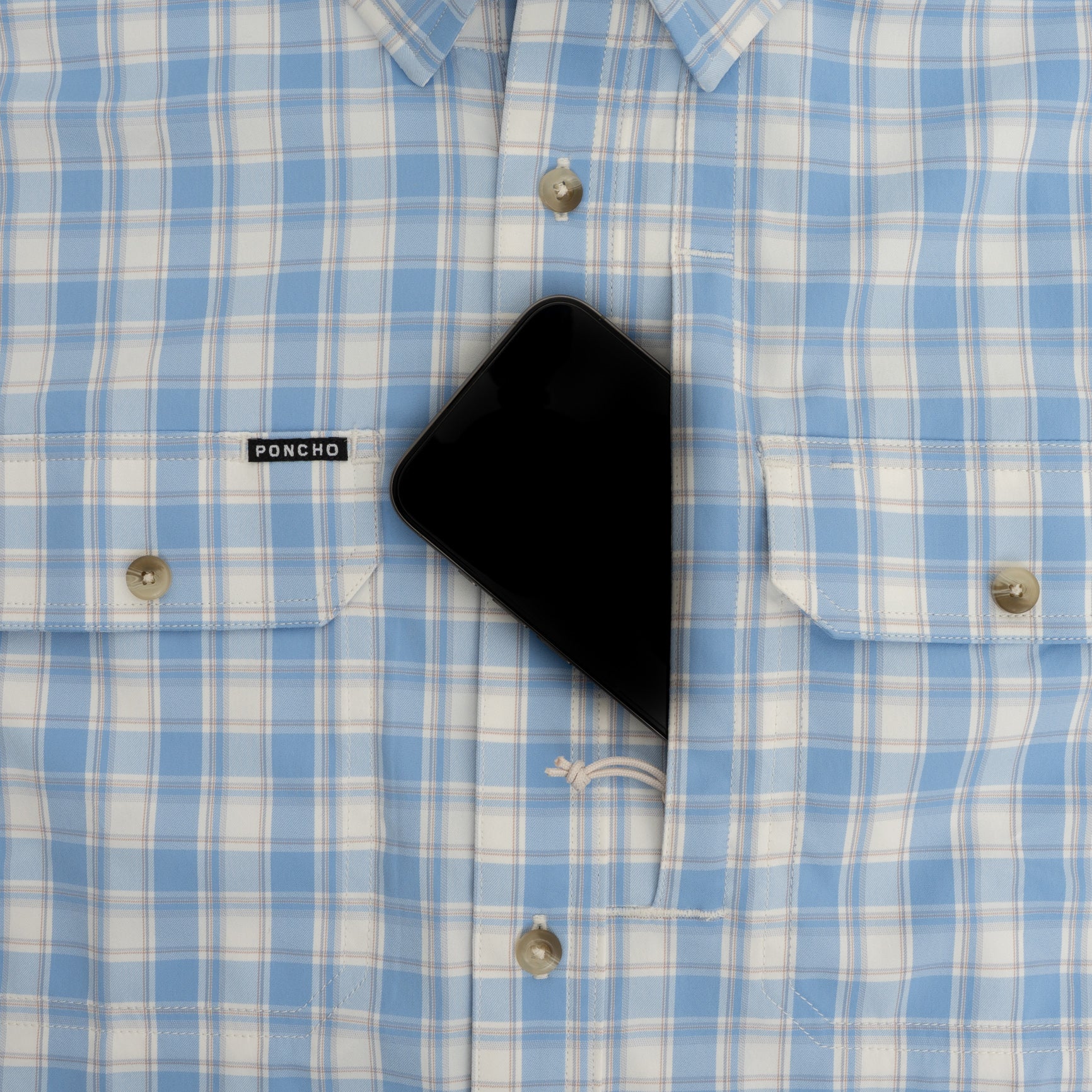 Phone in chest pocket of a blue plaid shirt