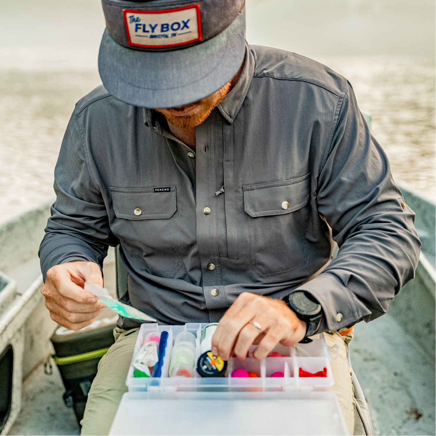 Close up photo of man gearing up for fly fishing in a drift boat