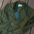 closeup of phone is chest pocket on moss green flannel shirt