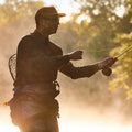 guy casting in river, silhouette against sunlight